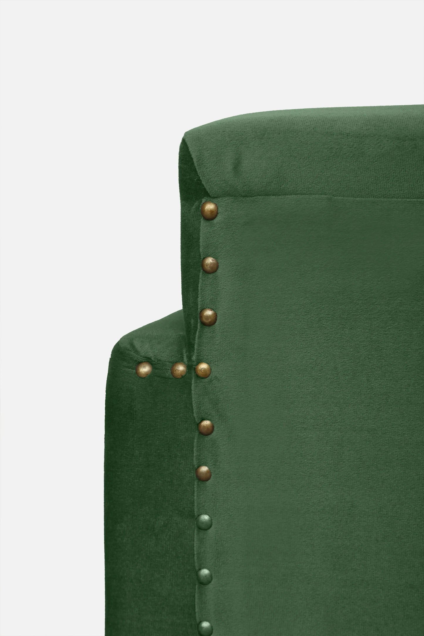Close-up of a green upholstered chair with brass nailhead trim on a white background