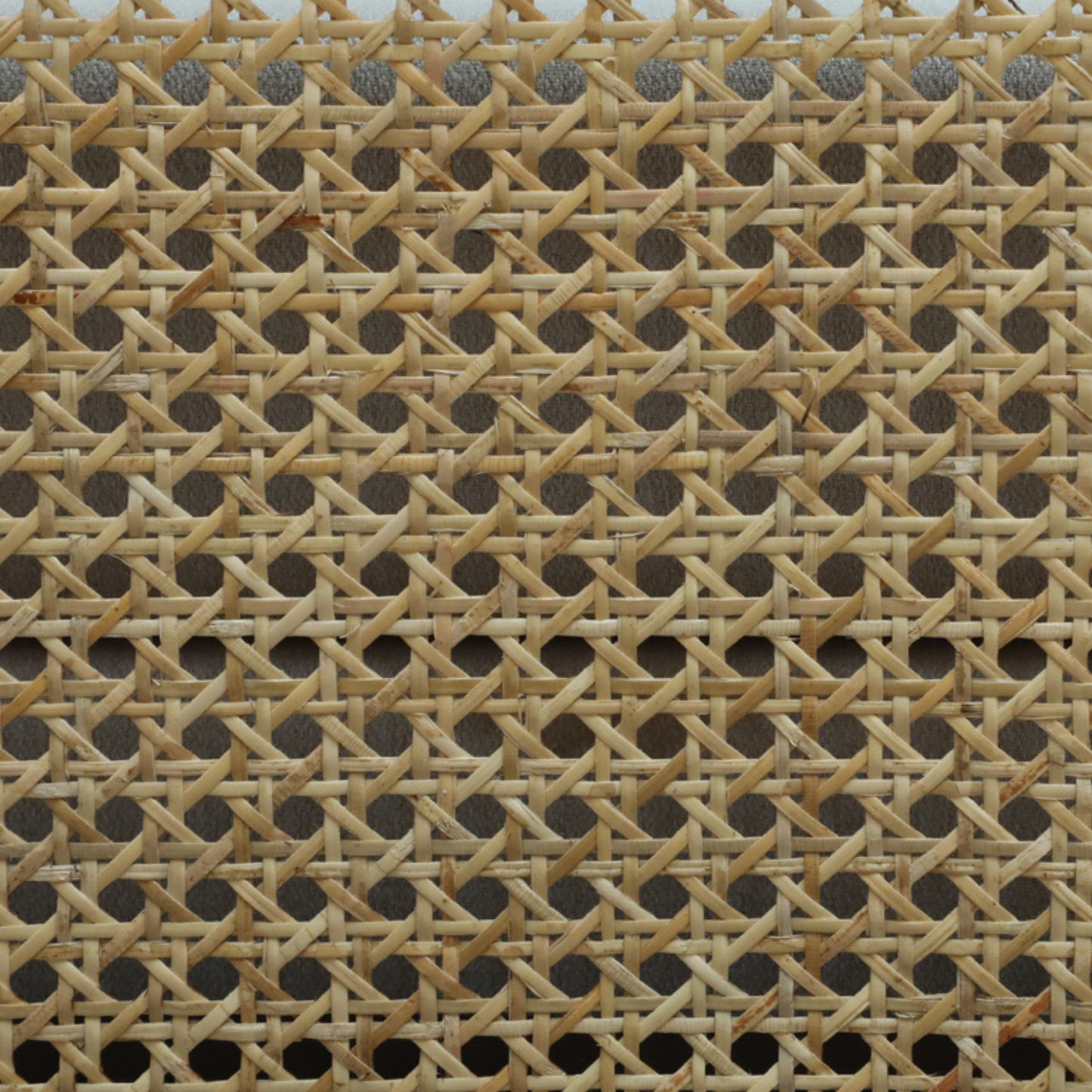 Close-up of a woven rattan texture with a geometric pattern.
