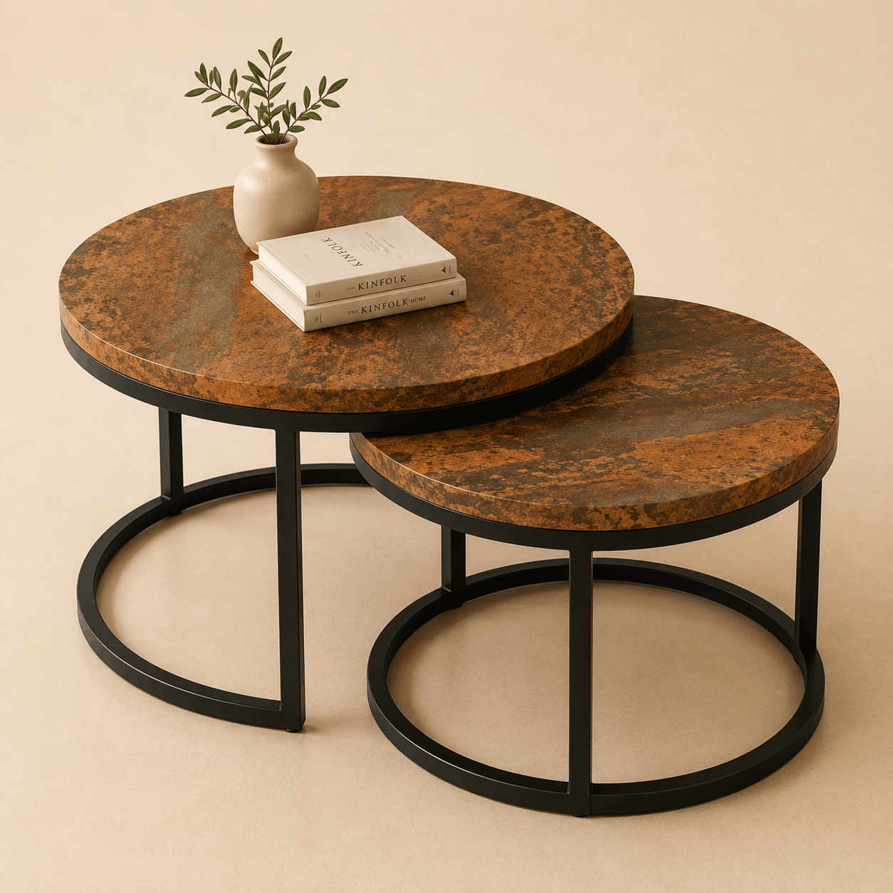 Set of two round marble coffee tables with black metal bases on a beige background