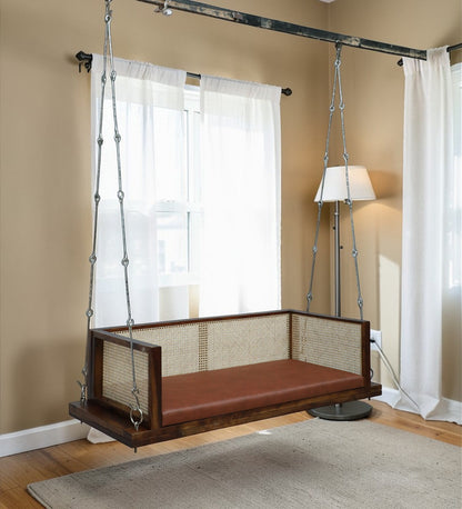 Solid wood hanging swing bench with cane back and brown cushion