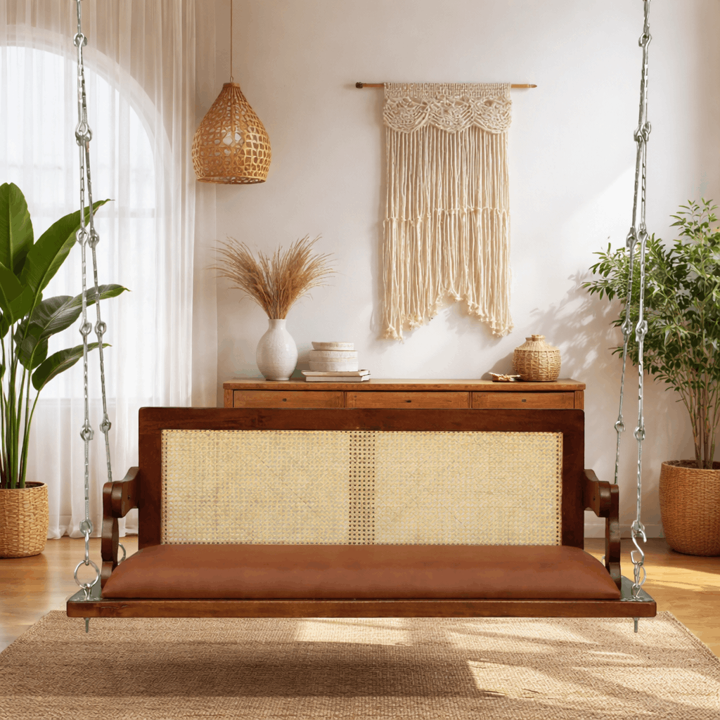 Wooden swing with woven backrest and cushion in a room with plants and decor.