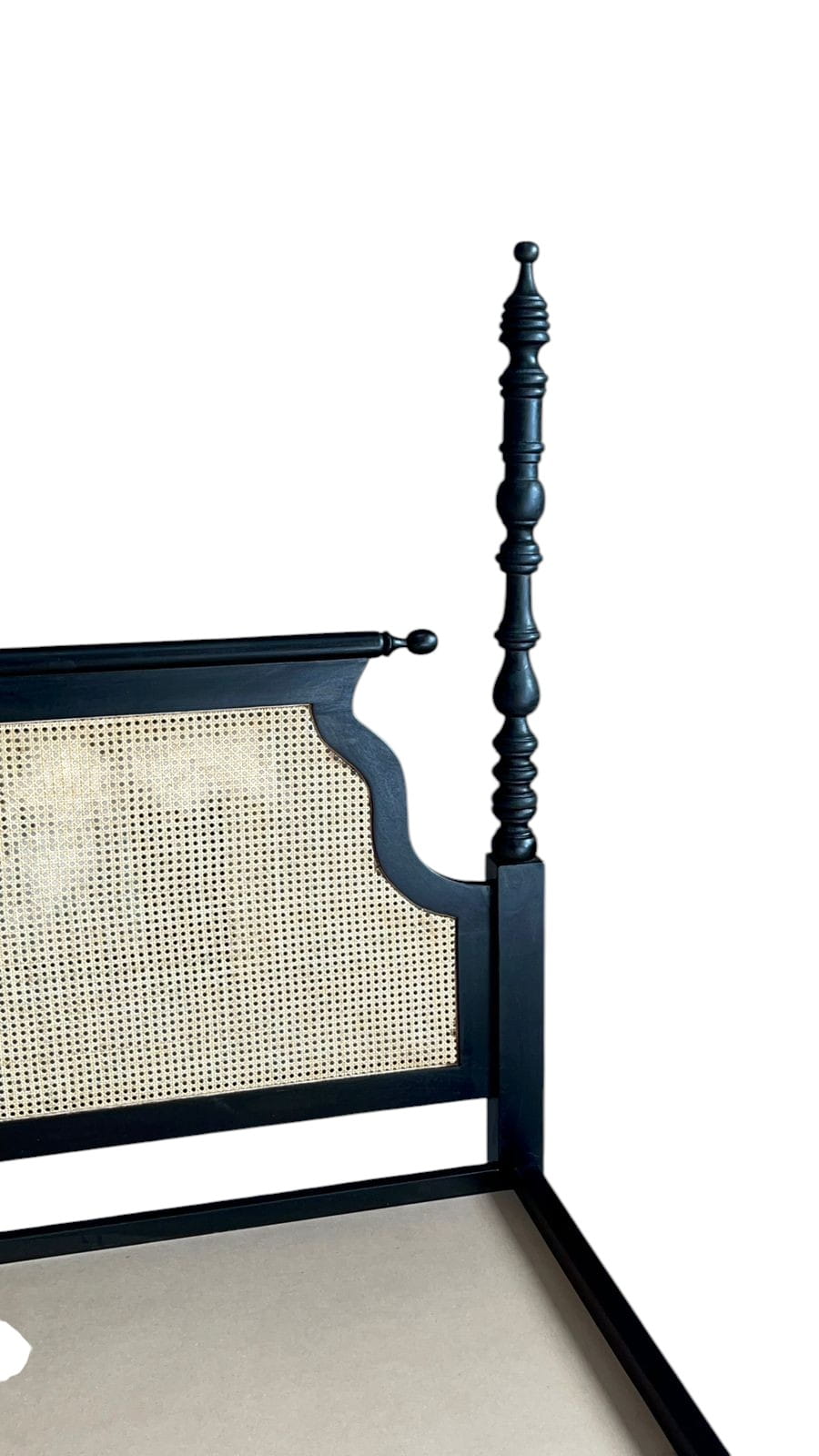 Black bed frame with caned headboard on a white background