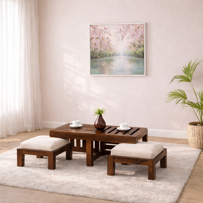 Wooden coffee table with two ottomans in a living room setting with a painting on the wall.