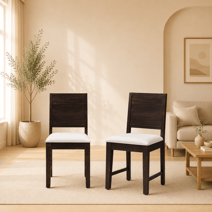 Two wooden chairs with white cushions in a living room setting.