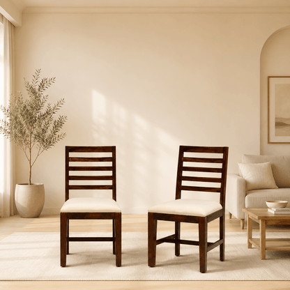 Two wooden chairs with white cushions in a living room setting.