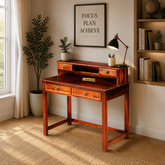 Wooden desk in a room with a framed poster, lamp, and plants.