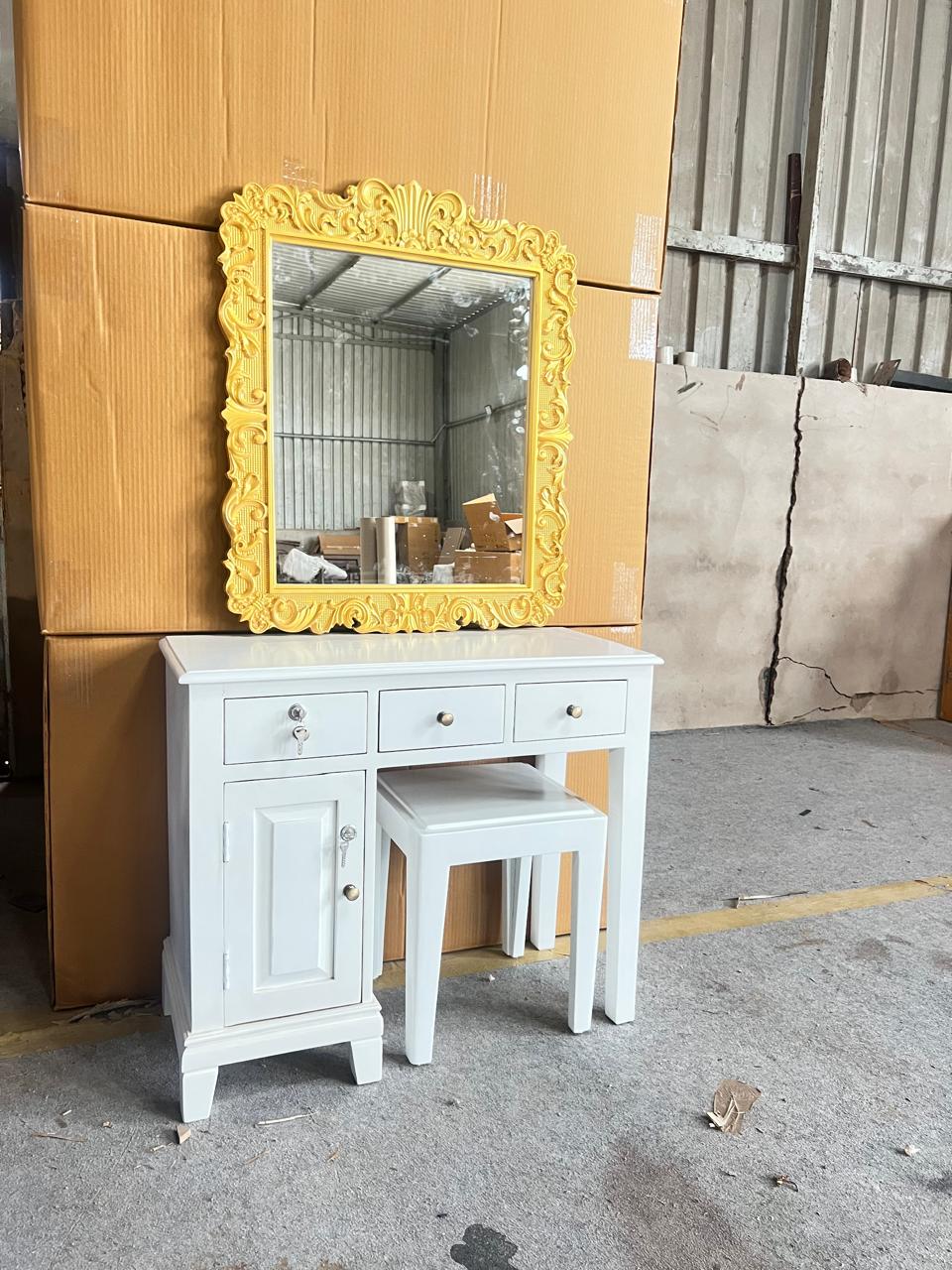 White vanity with yellow mirror against a wooden wall.