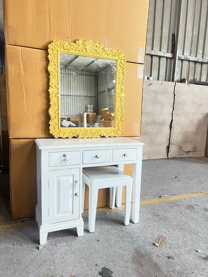 White vanity with yellow mirror against a wooden wall.
