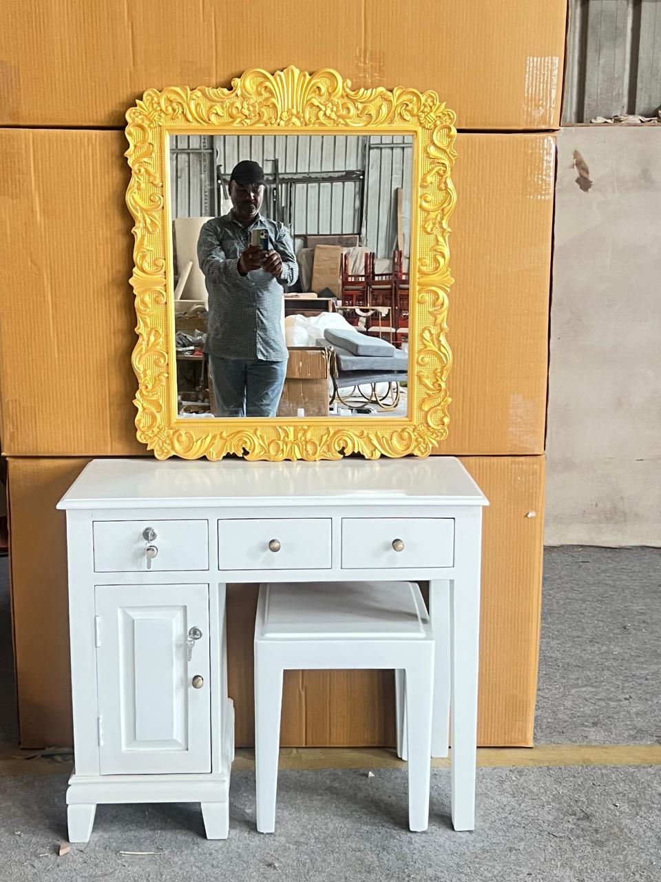 White vanity with yellow-framed mirror against a cardboard box background