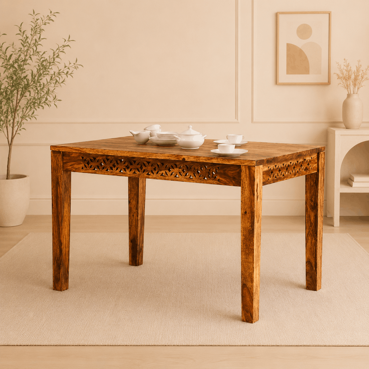 Wooden dining table with decorative items in a room with a plant and wall art.