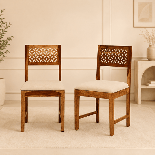 Two wooden chairs with decorative backrests in a room setting.