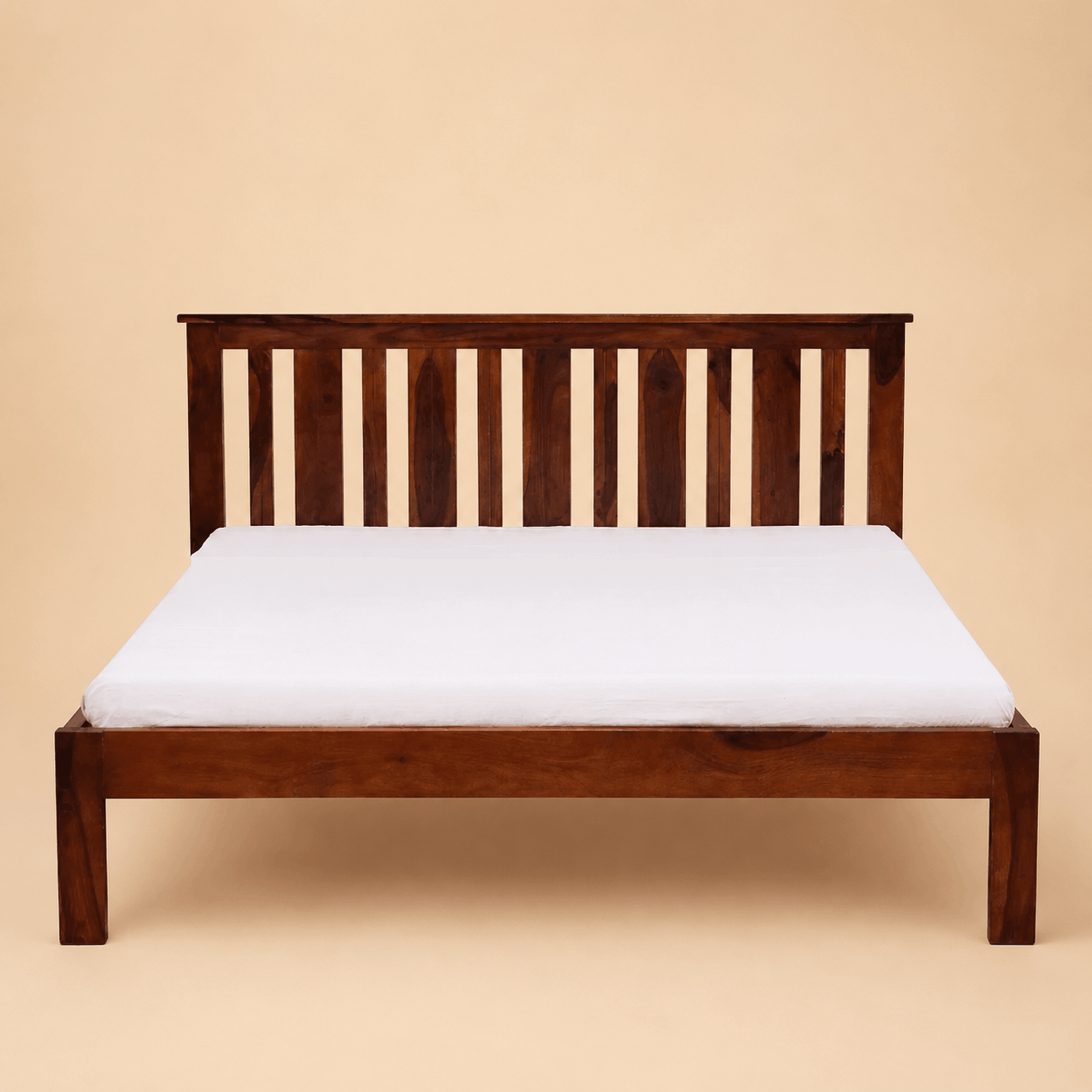 Wooden bed frame with a white mattress on a beige background