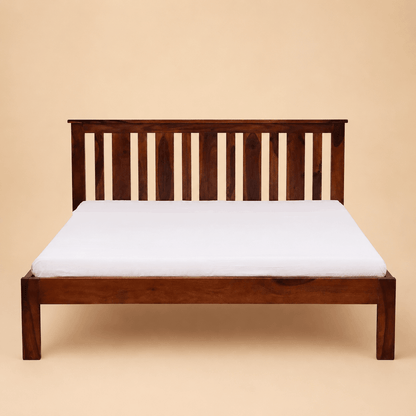 Wooden bed frame with a white mattress on a beige background