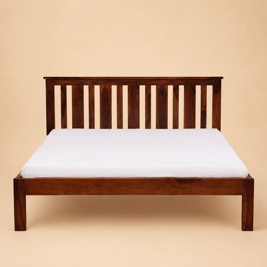 Wooden bed frame with a white mattress on a beige background