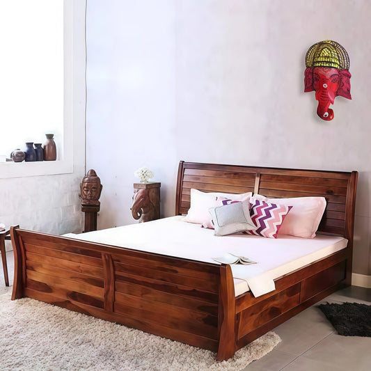 Wooden bed with decorative pillows in a room with a wall sculpture.