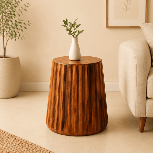 Wooden side table with a white vase and green plant in a living room setting.