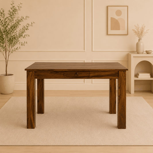 Wooden table in a room with a plant and shelf in the background