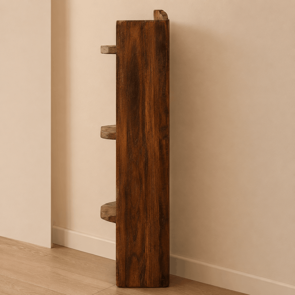 Wooden cat shelf with three levels against a beige wall.