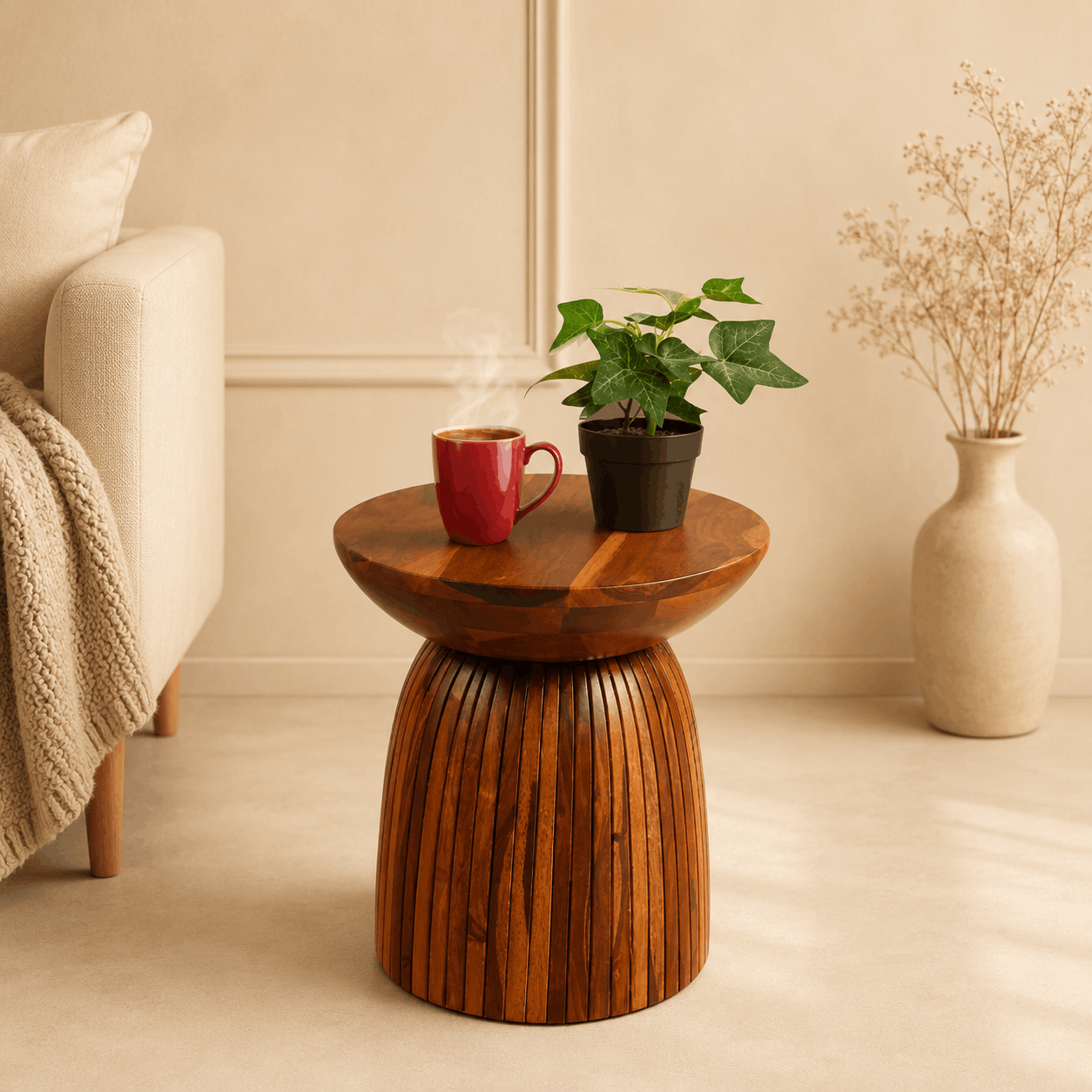 Wooden side table with a red mug, plant, and vase in a cozy living room.